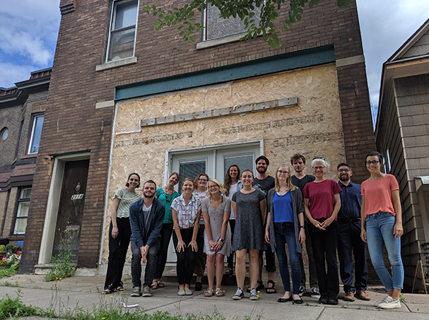 AmeriCorps VISTA volunteers stand in front of Legacy House Building before reconstruction.