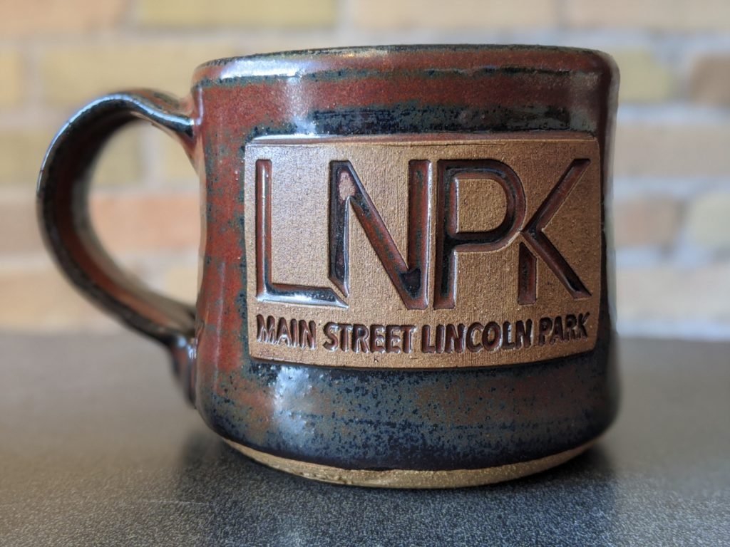 Duluth Pottery mug with Main Street Lincoln Park logo stamped on it.