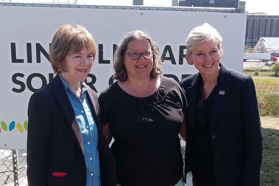 Sen. Smith, Jodi Slick, and Secretary Granholm pose in front of the Lincoln Park Solar Garden sign.