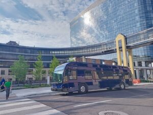 New blue DTA bus parked in front of the Essentia building.