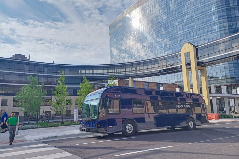 New blue DTA bus parked in front of the Essentia building.