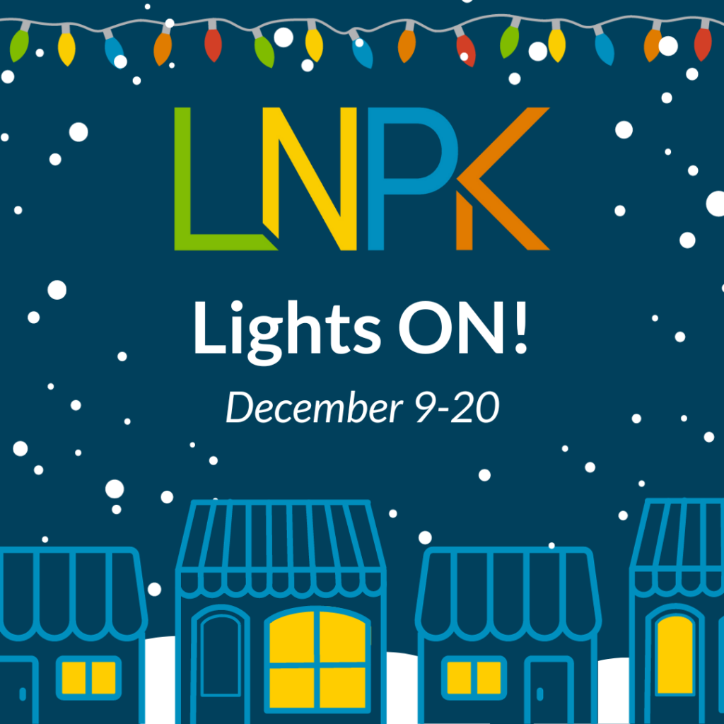 LNPK logo on navy background. Text reads "Lights ON! December 9-20" Graphics show a string of holiday lights runs across the top and four drawings of small shops (with yellow lighted windows) are across the bottom. White snow is falling.