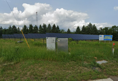 Solar array in green field. Sign in field has MN Power logo.