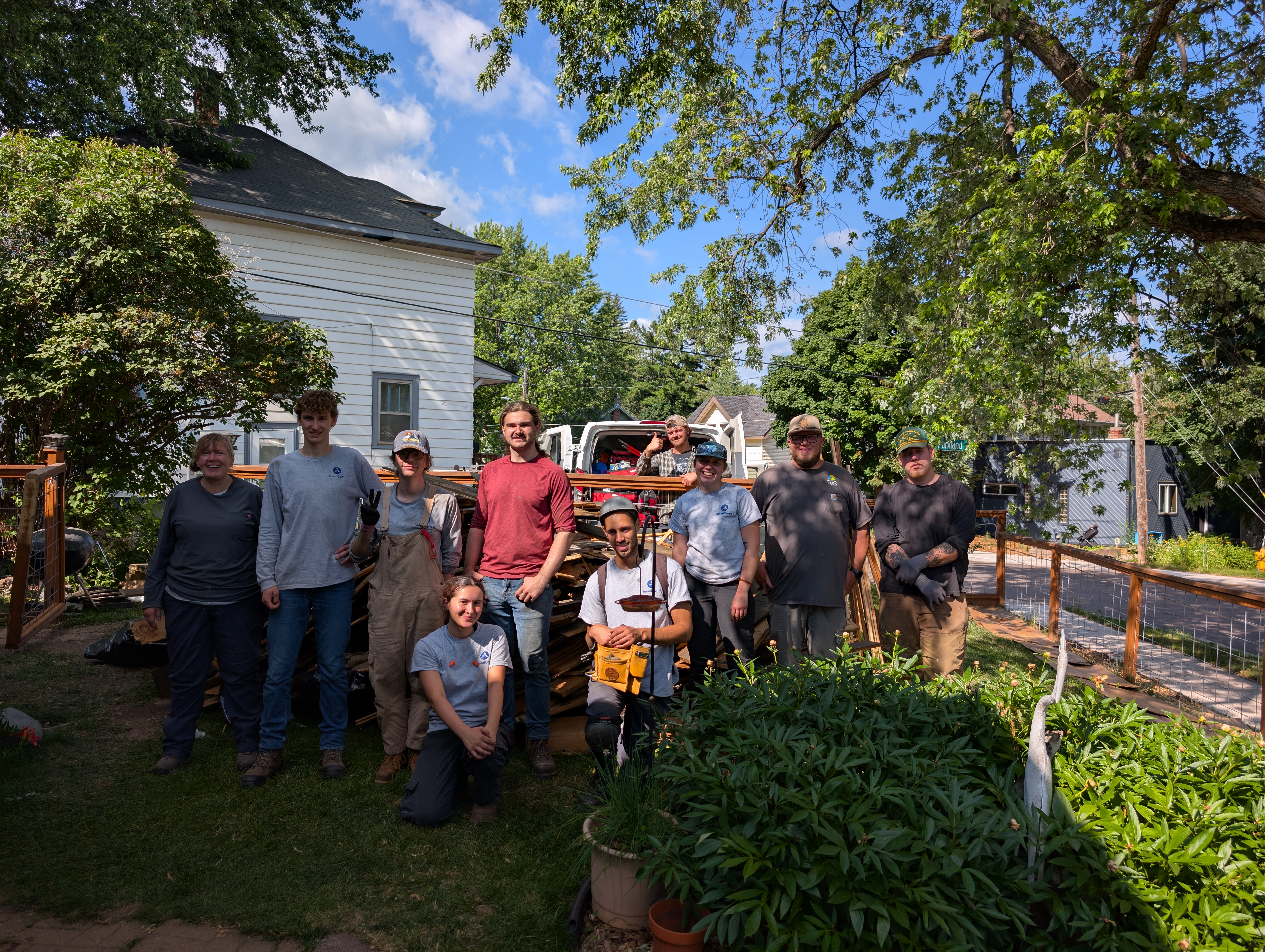 Group of people stand in front of a house.